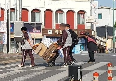 지난 27일 오후 아산 온천동 아고사거리에서 할머니를 도와 손수레를 끌고 있는 학생들이 포착됐다. ('보배드림')