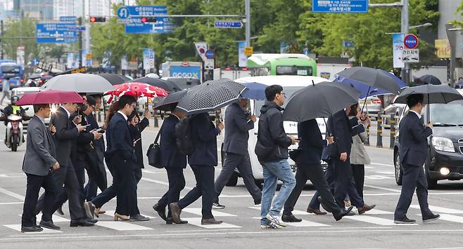 봄비가 내리는 지난 25일 오전 서울 시내 한 거리에서 우산을 쓴 시민들이 길을 지나고 있는 모습./뉴스1