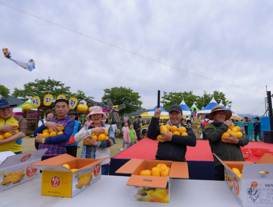 경북 성주군에서 열린 ‘성주 참외 & 생명문화축제’에서 참가자들이 참외를 들고 환하고 웃고있다. 경북도청 제공