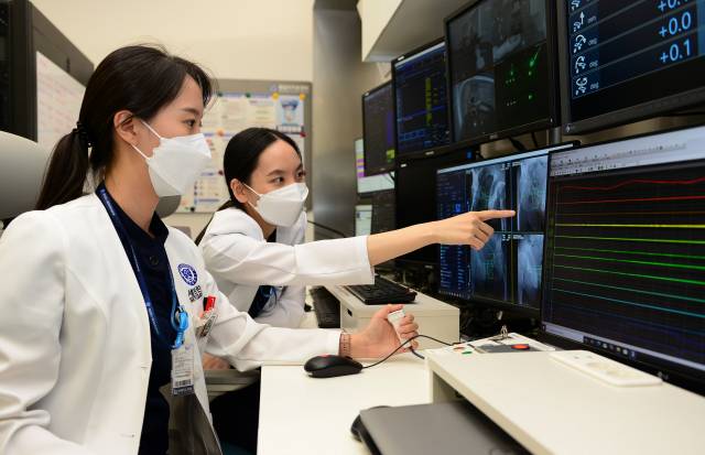 의료진이 조정실에서 엑스레이 검사에서 중입자 조사 위치를 확인하고 있다. 조정실은 치료 과정 전반을 관장하는 곳이다. 사진 제공=연세의료원