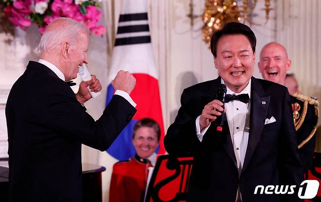 미국을 국빈 방문한 윤석열 대통령이 26일(현지시간) 워싱턴 DC 백악관에서 열린 국빈만찬에서 마이크를 잡고 노래를 부르자 조 바이든 미국 대통령이 어깨춤을 추며 흥겨워 하고 있다. ⓒ 로이터=뉴스1 ⓒ News1 김성식 기자