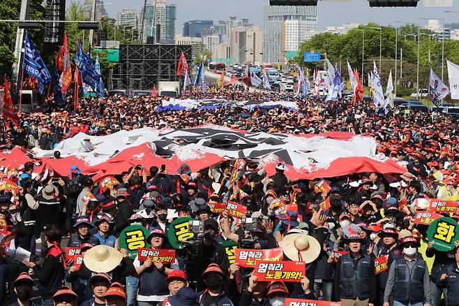 한국노총 조합원들이 1일 오후 서울 여의도 여의대로에서 열린 전국노동자대회에서 노동개악, 민생파탄 문구가 적힌 현수막을 찢는 상징 의식을 하고 있다. /뉴스1