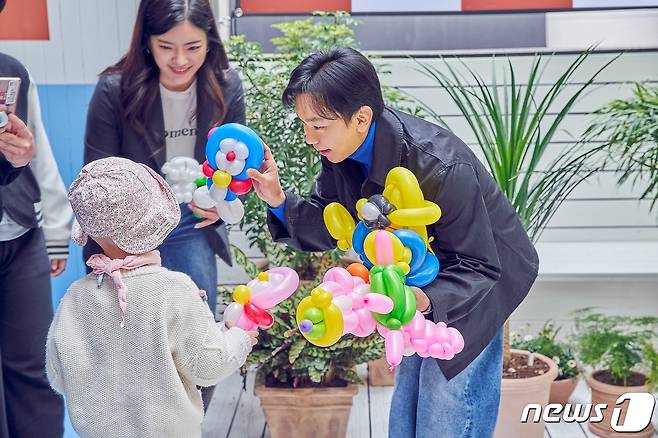 25일 삼성서울병원 환아 가족 초청행사에서 안정호 시몬스 대표가 풍선을 건네고 있다. (시몬스 제공)