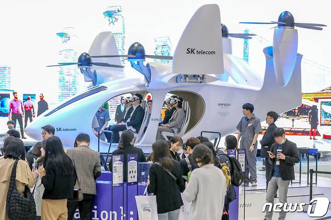 서울 강남구 코엑스에서 지난달 19일 열린 '2023 월드IT쇼'를 찾은 관람객들이 SK텔레콤의 도심항공교통(UAM) 체험을 하고 있다.  ⓒ News1