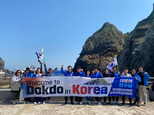 더불어민주당 전국청년위원회가 2일 독도에서 'Welcome to Dokdo in Korea'라고 쓴 현수막과 태극기를 들고 "독도는 우리 땅"을 외치고 있다.<전용기 의원실 제공>