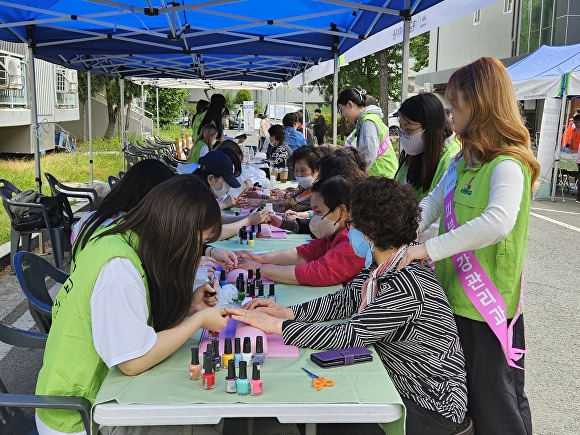 수성대학교 피부건강관리과 학생들이 3일 어르신들에게 네일아트, 손 마사지 봉사활동을 펼치고 있다. [사진=수성대학교]