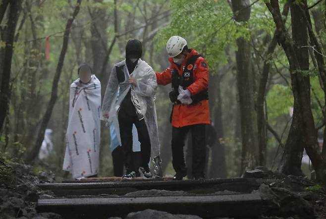 3일 오후 제주 한라산 성판악 입구에 도착한 학생들이 구급대원의 부축을 받으며 진료소로 향하고 있다. /사진=뉴시스