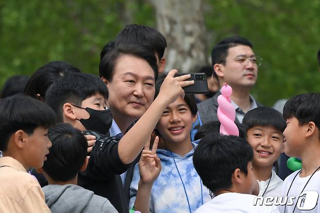 윤석열 대통령이 4일 용산 대통령실 앞 용산어린이정원에서 열린 개방 행사에서 어린이들과 셀카를 찍고 있다. (대통령실 제공) 2023.5.4/뉴스1 ⓒ News1 오대일 기자