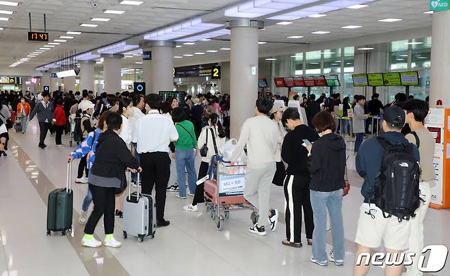 4일 오후 제주국제공항 3층 출발장에 있는 한 항공사 발권 창구 앞에 대체 항공편을 구하려는 이용객들로 붐비고 있다. 2023.5.4/뉴스1 ⓒ News1 오미란 기자