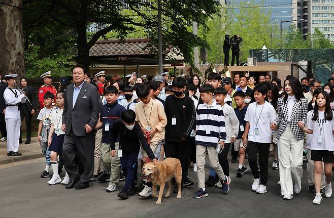 윤석열 대통령과 부인 김건희 여사가 4일 서울 용산 어린이정원에서 열린 개방행사에서 어린이들과 손을 잡고 입장하고 있다. [연합]