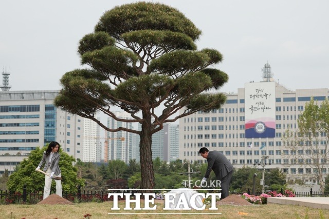 윤석열 대통령과 김건희 여사가 4일 용산어린이정원 기념식수를 위해 삽으로 흙을 뿌리는 모습. /대통령실