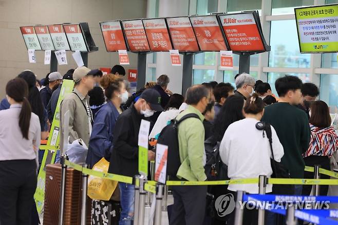 기약 없는 기다림 (제주=연합뉴스) 박지호 기자 = 5일 오전 제주국제공항 출발층 항공사 카운터가 결항편 대체 항공권을 구하려는 여행객들로 붐비고 있다. 2023.5.5 jihopark@yna.co.kr