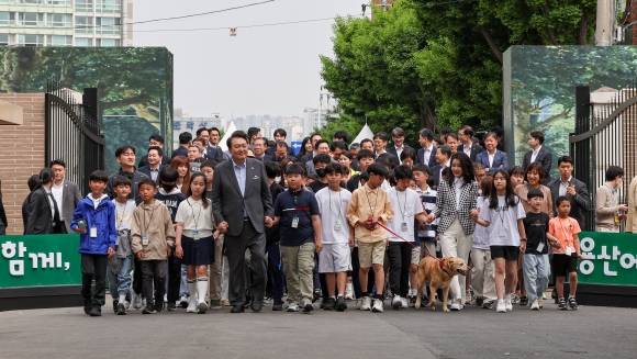 어린이들과 손잡고 용산어린이정원 입장하는 윤 대통령 부부 - 윤석열 대통령과 부인 김건희 여사가 4일 서울 용산 어린이정원에서 열린 개방행사에서 어린이들과 손을 잡고 입장하고 있다. -연합뉴스