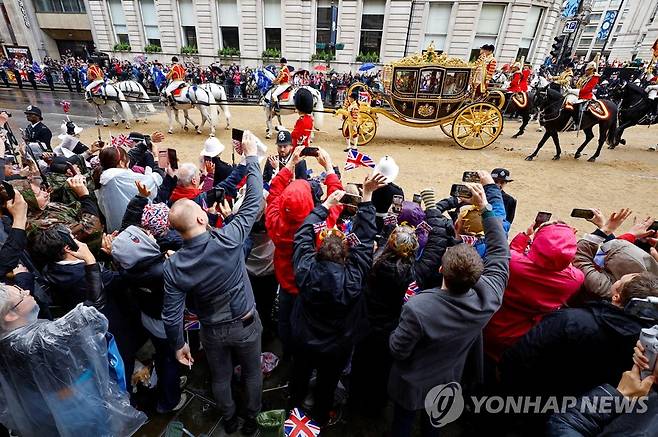 '왕의 행렬' 지켜보는 시민들 (런던 로이터=연합뉴스) 영국 찰스 3세 국왕의 대관식이 열리는 6일(현지시간) 국왕 행렬이 웨스트민스터 사원으로 향하고 있다. 2023.5.6 photo@yna.co.kr