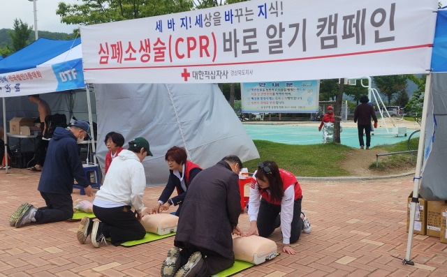 대구에서 7일 열린 철인3종대회 부스에 마련된 심폐소생술 홍보부스에서 대한적십자사 경북지사 응급처치강사봉사회 강사들이 대회에 참가한 선수들과 가족들에게 심폐소생술 시범을 보이고 있다. 대한적십자사 경북지사 제공