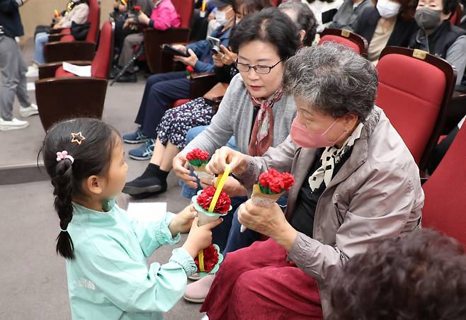 4일 오전 경기도 수원시 팔달노인복지관에서 어린이집 원아들이 어버이날을 앞두고 어르신들에게 카네이션을 건네고 있다. [연합]