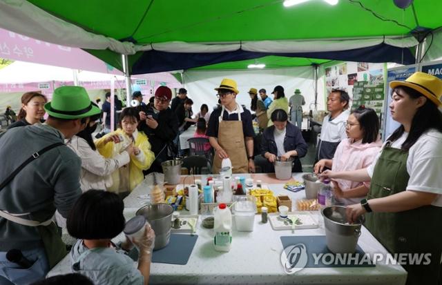 어린이날인 5일 강원 양구군 서천 레포츠공원에서 열린 '2023 양구 곰취축제'에서 가족 단위 방문객들이 곰취 아이스크림 만들기를 체험하고 있다. 연합뉴스