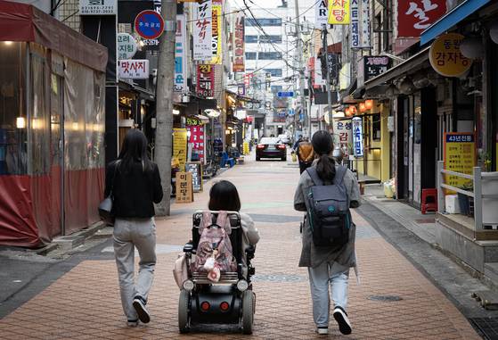 ‘장애인의 날’이었던 지난달 20일 서울 영등포구청역 인근 상가거리에서 왼쪽부터 휠비 데이터 리서처 곽은혜(28)씨, 한경아(39)씨, 윤지영(24)씨가 휠체어 이용이 가능한 식당 및 카페를 찾고 있다. 최기웅 기자