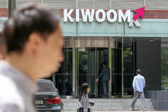 People walk past Kiwoom Securities office in Yeouido, western Seoul, on May 4. [NEWS1]