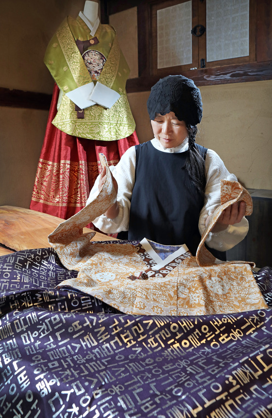 Lee neatly folds hanbok in Cheongju, North Chungcheong. [PARK SANG-MOON]