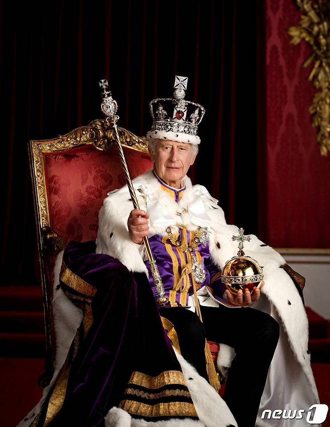 찰스 3세 영국 국왕이 8일(현지시간) 런던 버킹엄 궁에서 왕관을 쓰고 두 손에는 왕을 상징하는 보주와 홀을 들고 왕좌에 앉아 있는 대관식 기념 사진을 공개하고 있다. ⓒ 로이터=뉴스1 ⓒ News1 우동명 기자