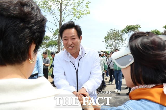 오세훈 서울시장이 국가정원에 관람온 시민과 만나 반갑게 악수를 하고 있다. /순천시