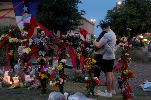 총기난사로 8명이 숨진 미국 텍사스주 알렌의 쇼핑몰 앞 마련된 추모공간에서 추모객들이 애도하고 있다. 게티이미지/AFP연합뉴스