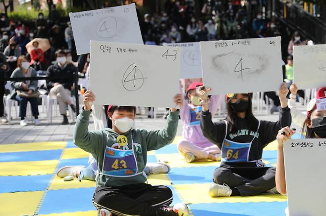 서울 강북구가 지난해 10월 우이동 만남의 광장에서 개최한 ‘제1회 민주시민 골든벨’에서  학생들이 보드판에 적힌 정답을 들어올리고 있다. |강북구 제공