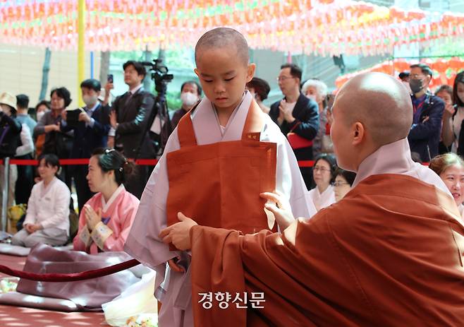 동자승들이 삭발 후 장삼을 착복하고 있다.