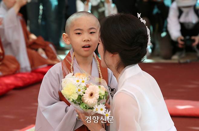 동자승들이 삭발ㆍ수계식 후 엄마에게서 꽃다발을 받고 있다.