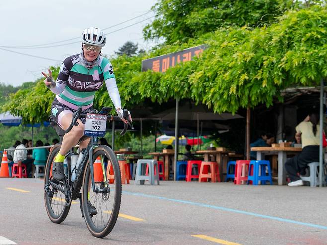 캐나다 티디에이 글로벌 사이클링(TDA Global Cycling) 동호회 회원이 양평 포장마차 골목을 지나면서 손인사를 하고 있다.