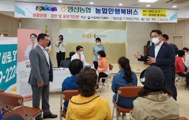 경남농협본부가 창녕 영산농협에서 진행한 ‘농업인행복버스’에서 박성기 조합장(맨 왼쪽)과 이창훈 경남농협 부본부장(맨 오른쪽)이 진료를 기다리는 농업인들과 이야기를 나누고 있다.