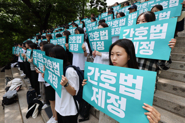 ▲ 이화여자대학교 간호대학 교수진과 학생들이 10일 서울 서대문구 이화여대 정문 광장에서 간호법 공포 촉구 기자회견을 열고 있다.[연합뉴스]