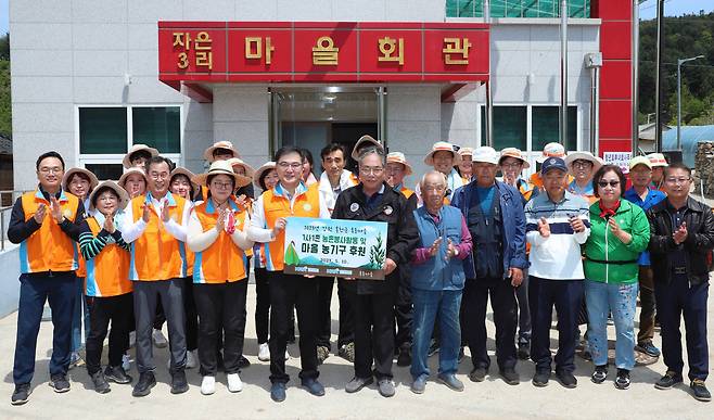 손병두 한국거래소 이사장이 10일 임직원 30여명과 강원 홍천군 후동마을 1사1촌을 방문해 '농촌일손돕기 봉사활동'에 앞서 이상필 강원 홍천 후동마을 이장에게 후원 물품을 전달하며 기념 촬영하고 있다. [연합]