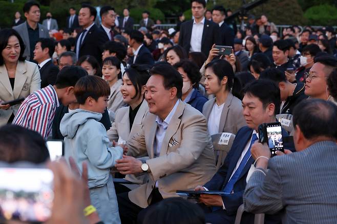 윤석열 대통령과 김건희 여사가 10일 오후 청와대 대정원에서 열린 ‘청와대 개방 1주년 기념 특별음악회’에 참석해 어린이들과 인사하고 있다. [연합]