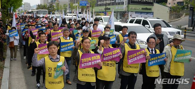 [전주=뉴시스] 김얼 기자 = 전라북도 보건복지의료연대 관계자들이 3일 전북 전주시 덕진구 가련광장 교차로 사거리에서 간호법·면허박탈법 강행처리 민주당 퇴출 400만 보건복지의료연대 규탄대회를 열고 구호를 외치고 있다. 2023.05.03. pmkeul@nwsis.com