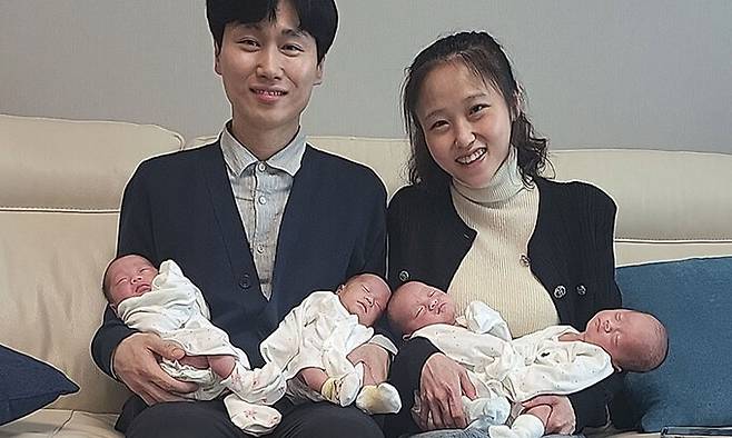 송리원 SK온 PM(왼쪽)과 아내 차지혜씨가 네쌍둥이를 품에 안고 웃고 있다. 네쌍둥이는 왼쪽부터 설록, 리지, 록시, 비전. SK온 제공