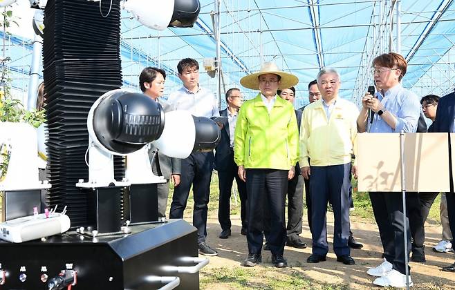 9일 경북 안동시 임하면 오대리에서 진행된 사과 스마트팜 공개 행사에서 이철우 경북도지사(가운데)를 비롯한 관계자들이 자율주행형 
인공지능(AI) 카메라를 살펴보고 있다. 자율주행형 AI 카메라는 스마트팜 내부를 자유롭게 돌아다니면서 사과나무의 병충해 피해 
상황과 과실 상태 정보를 수합해 농장주에게 알려준다. 경북도 제공