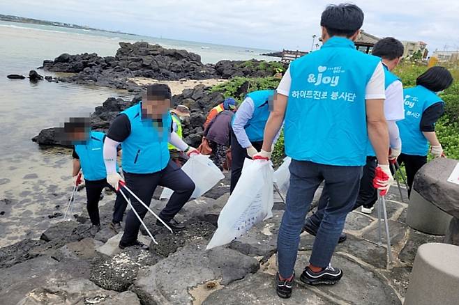 [제주=뉴시스] 하이트진로 관계자들이 지난 2022년 6월 8일 반려해변인 표선해수욕장에서 환경정화 활동을 하고 있다. (사진=바다가꾸기 홈페이지 갈무리) 2023.05.11. photo@newsis.com *재판매 및 DB 금지