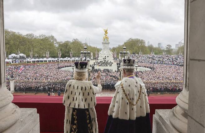 찰스 3세와 카밀라 왕비가 런던 버킹엄궁 발코니에서 대관식 축하 인파를 내다보고 있다. (런던 AP=연합뉴스)