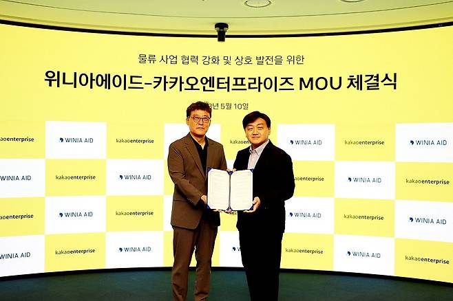 위니아에이드와 카카오엔터프라이즈가 11일 물류사업 협력을 위한 MOU를 체결했다. 이 자리에 백상엽 카카오엔터프라이즈 대표(오른쪽)가 업무 협약식에 참석한 백성식 위니아에이드 대표(왼쪽)와 기념사진을 찍은 모습/ 위니아