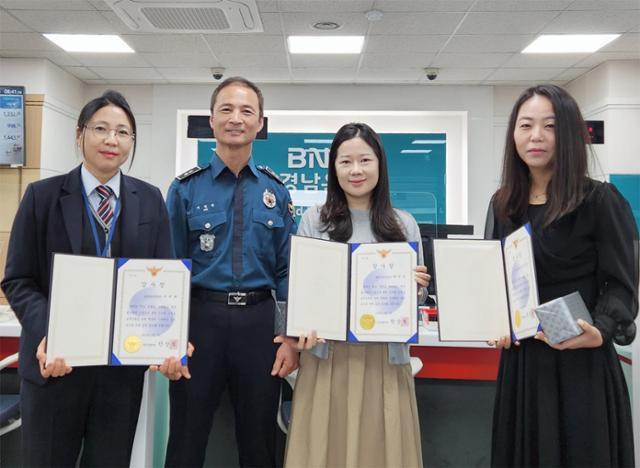 BNK경남은행 양산기업금융지점 직원들이 보이스피싱을 예방한 공로로 양산경찰서 명의의 감사장을 받고 있다. BNK경남은행 제공