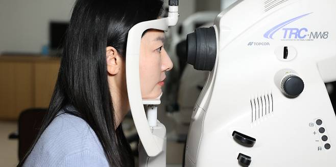 30대 여성이 동공을 통해 안저에 있는 망막과 시신경유두, 황반 등 안구 내 구조물을 촬영하는 안저검사를 받고 있다. 김안과병원 제공