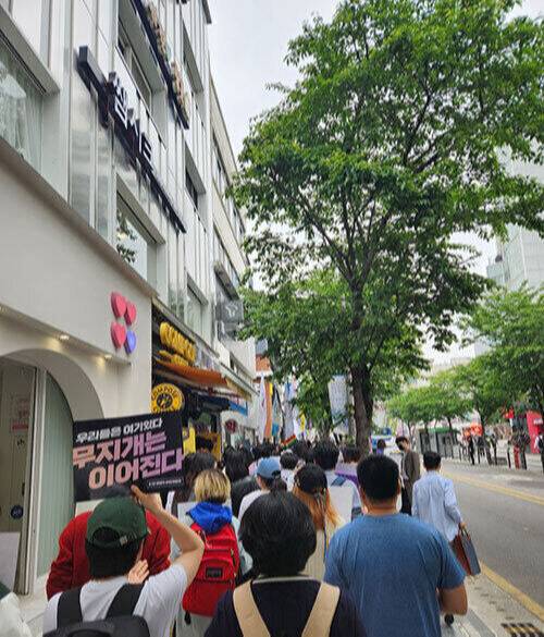 ‘무지개는 이어진다’라고 적힌 피켓을 든 집회&nbsp;참석자가 서울 서대문구 연세로를 따라 행진하고 있다.