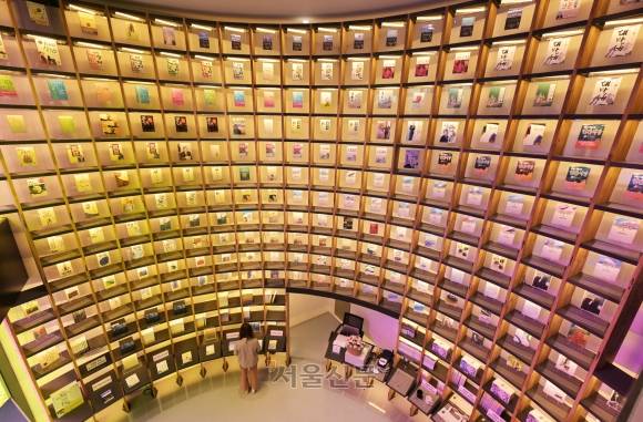 논산 김홍신 문학관 내부 모습. ‘인간시장’ 등 그의 대표작들로 한쪽 벽을 가득 채웠다. 알록달록한 문학관 파사드, 작가의 친필 원고 등 볼거리도 많아 쉬어 가기 딱 좋다. 무료로 운영된다.