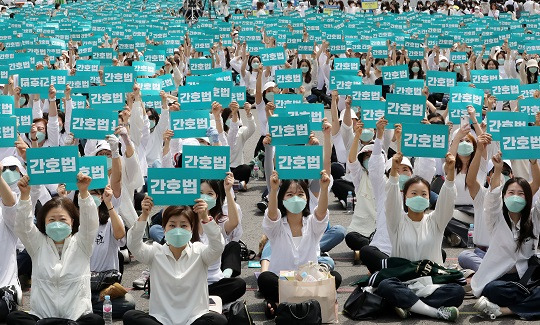 대한간호협회 간호사들이 지난 12일 오후 서울 동화면세점 앞 세종대로에서 열린 국제간호사의 날 기념 집회에서 피켓을 들고 간호법 제정을 촉구하고 있다. 사진=뉴스1