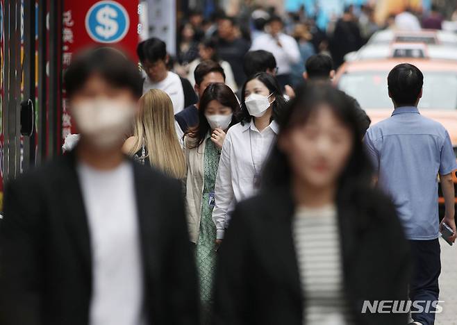 [서울=뉴시스] 김진아 기자 = 정부가 코로나19 위기 경보를 '심각'에서 '경계'로 하향하겠다고 밝혀 사실상 '엔데믹(endemic·풍토병으로 굳어진 감염병)'을 선언한 다음 날인 12일 서울 중구 명동에서 마스크를 쓰거나 쓰지 않은 시민들이 발걸음을 옮기고 있다. 2023.05.12. bluesoda@newsis.com