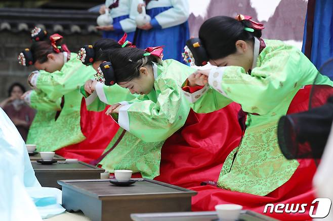 성년의날을 하루 앞둔 14일 오후 서울 중구 덕수궁 돌담길에서 열린 '전통 성년례'에서 올해 성년을 맞은 대학생들이 의복과 족두리를 착용하는 가례(加禮)를 치른 뒤 절을 하고 있다. 2023.5.14/뉴스1 ⓒ News1 민경석 기자