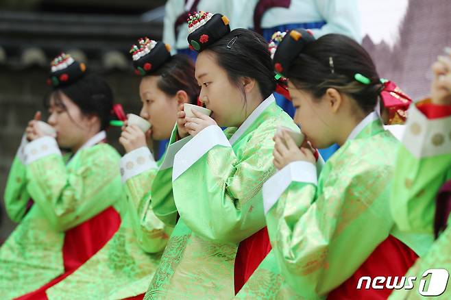 성년의날을 하루 앞둔 14일 오후 서울 중구 덕수궁 돌담길에서 열린 '전통 성년례'에서 올해 성년을 맞은 대학생들이 차를 마시는 초례(醮禮)를 치르고 있다. 2023.5.14/뉴스1 ⓒ News1 민경석 기자