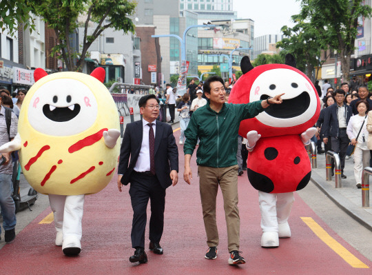 오세훈(오른쪽) 서울시장과 박강수 마포구청장이 13일 오후 서울 마포구 지하철 홍대입구역 인근에서 열린 '제1회 레드로드 축제 선포식'에서 조성된 레드로드를 둘러보고 있다. 레드로드는 경의선숲길부터 홍대, 당인리발전소까지 이어지는 약 2㎞ 길이의 홍대 문화예술관광특구 테마거리다.  [마포구 제공]